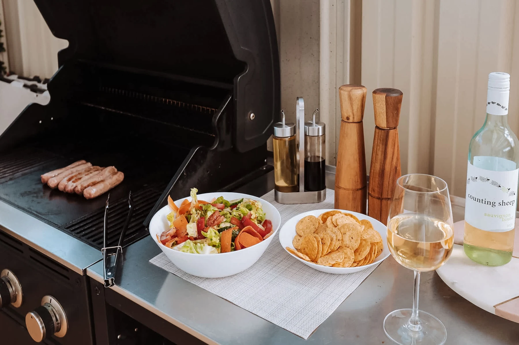 BBQ with salad, snacks and wine in the backyard